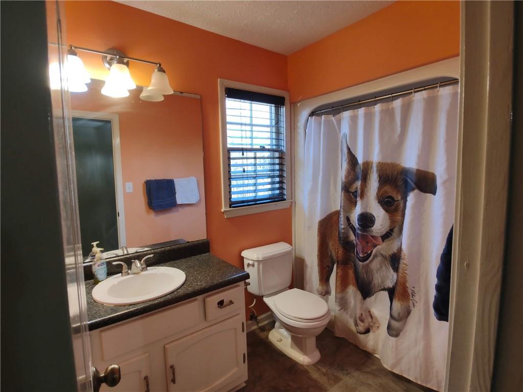 23 The Trail Southeast Lindale, GA 30147 - Photo 20 of 37 a bathroom with a granite countertop sink toilet a mirror and shower