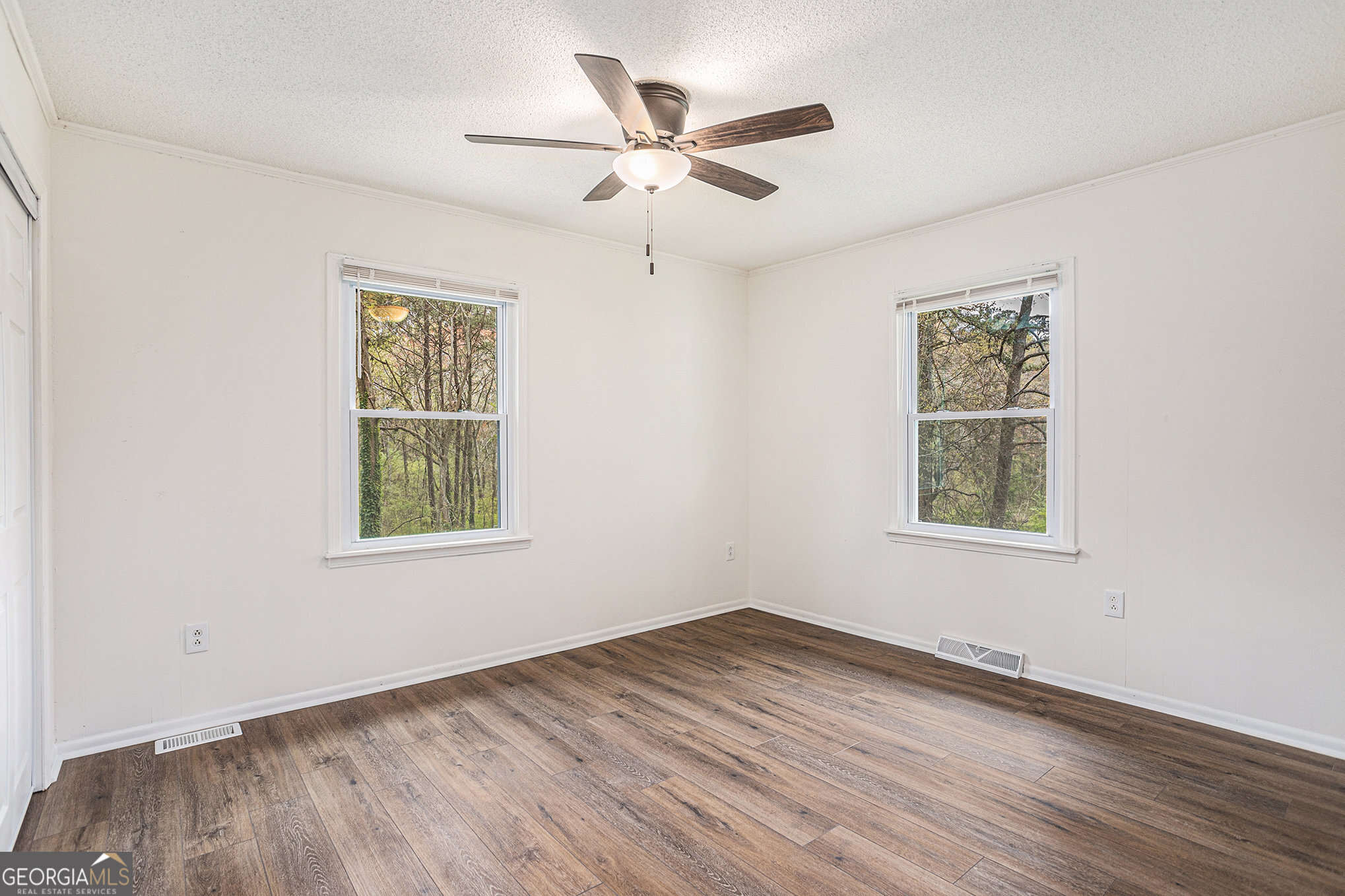 1113 Lake View Drive Jonesboro, GA 30236 - Photo 14 of 25 an empty room with wooden floor ceiling fan and windows