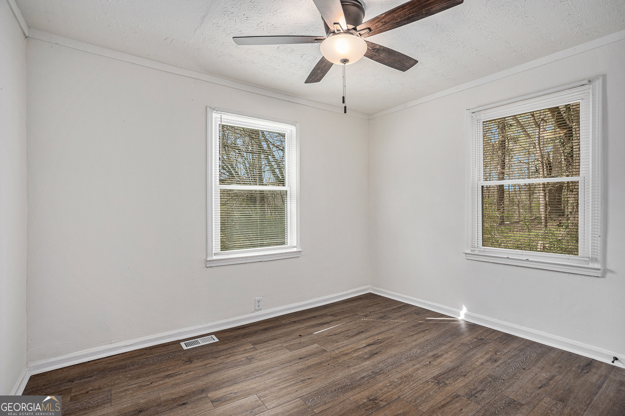 1113 Lake View Drive Jonesboro, GA 30236 - Photo 16 of 25 an empty room with wooden floor ceiling fan and windows