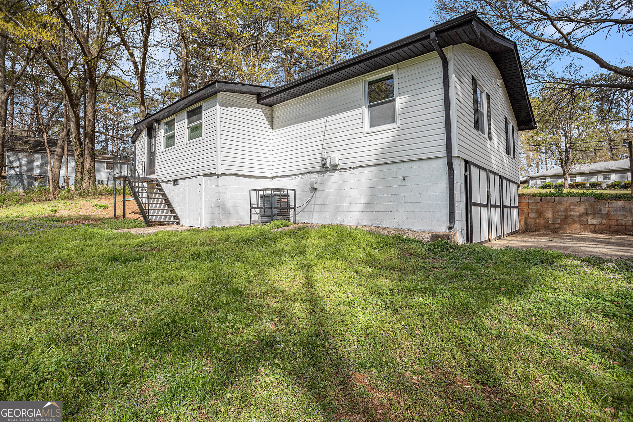 1113 Lake View Drive Jonesboro, GA 30236 - Photo 23 of 25 a white house that has a small yard and a large trees with wooden fence