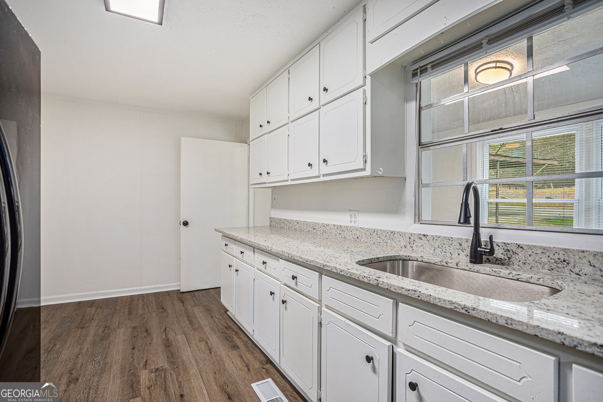 1113 Lake View Drive Jonesboro, GA 30236 - Photo 8 of 25 a kitchen with granite countertop a sink and cabinets with wooden floor