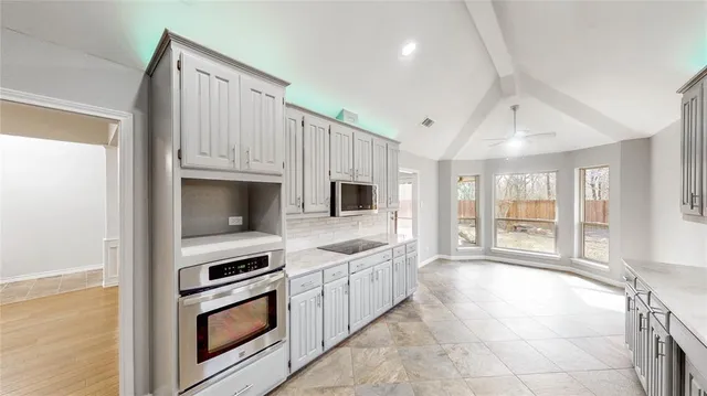a kitchen with stainless steel appliances granite countertop a stove and a microwave