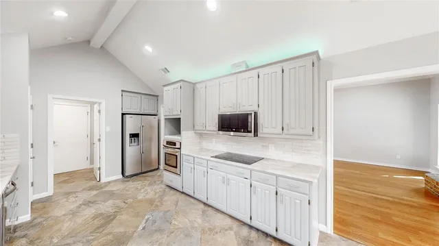 a kitchen with white cabinets and stainless steel appliances