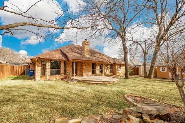 a front view of residential houses with yard and trees