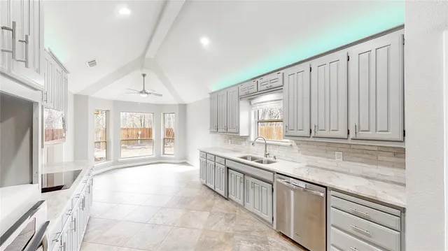 a kitchen with stainless steel appliances granite countertop a sink and a white cabinets