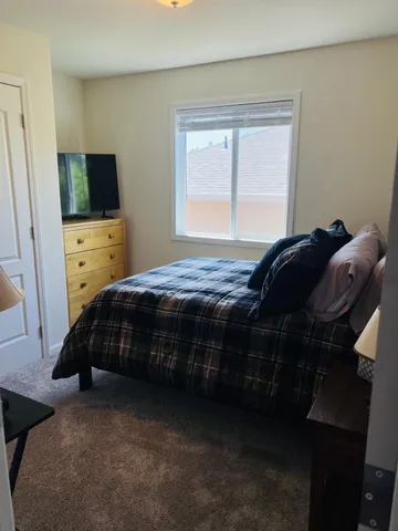 a bedroom with a bed and a flat screen tv