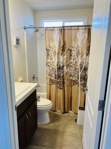 a bathroom with a granite countertop sink toilet and shower