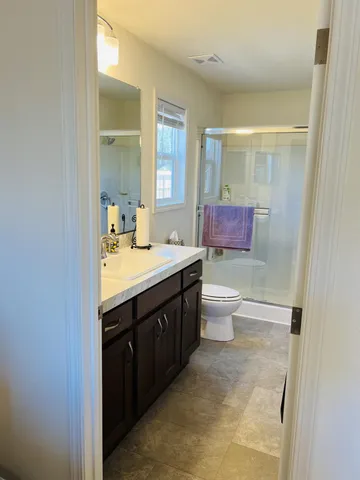 a bathroom with a double vanity sink toilet and mirror