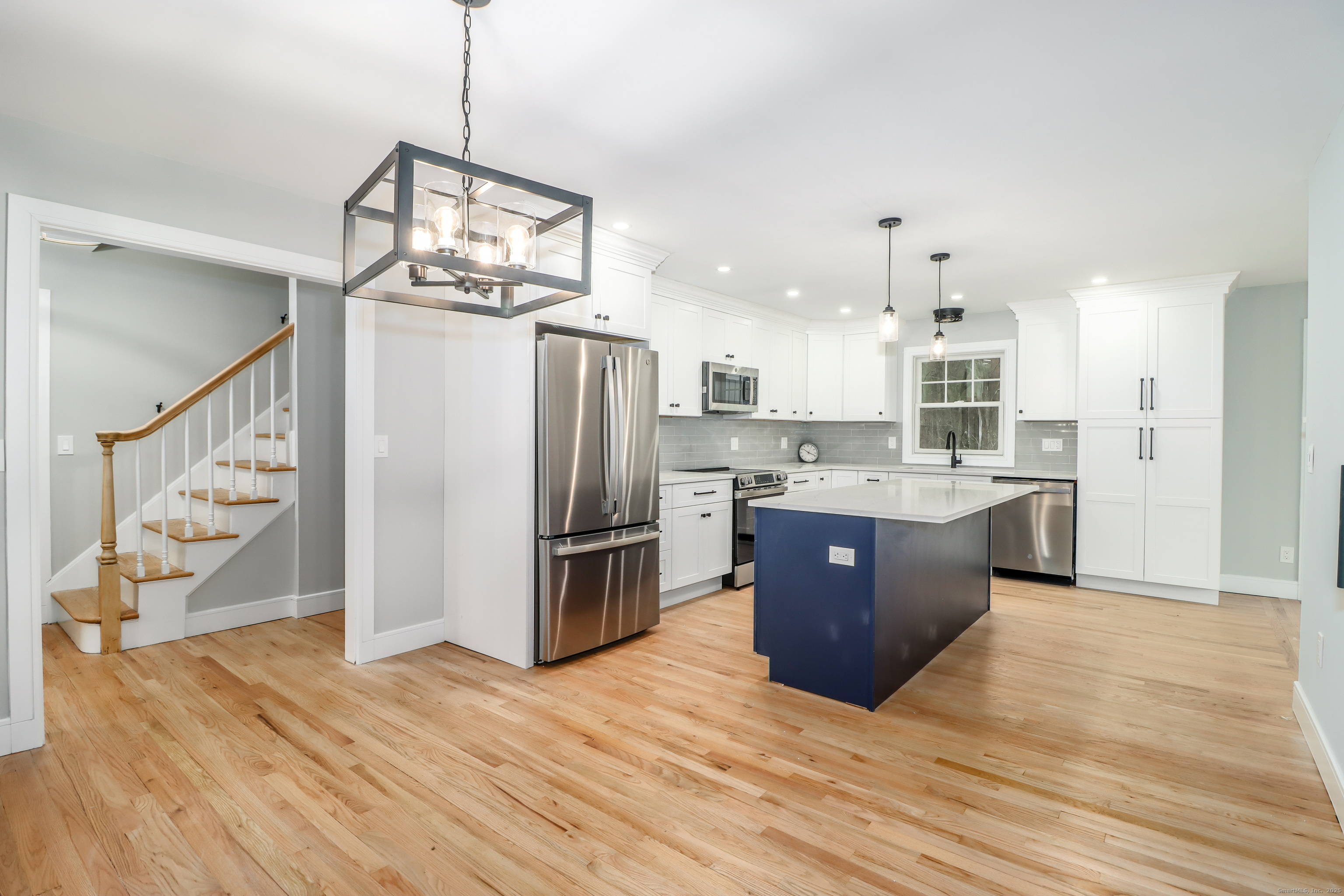 5 Antler Pine Road Newtown, CT 06482 - Photo 9 of 38 a large kitchen with stainless steel appliances granite countertop a refrigerator a sink dishwasher a oven and a dining table with wooden floor