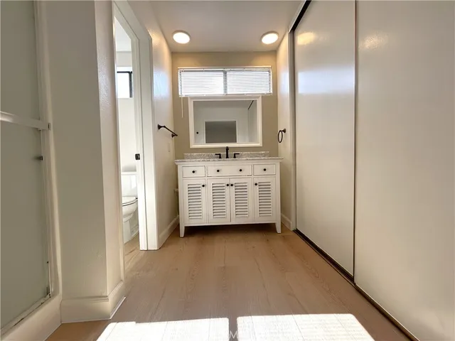 a en suite bathroom with a sink mirror and a shower