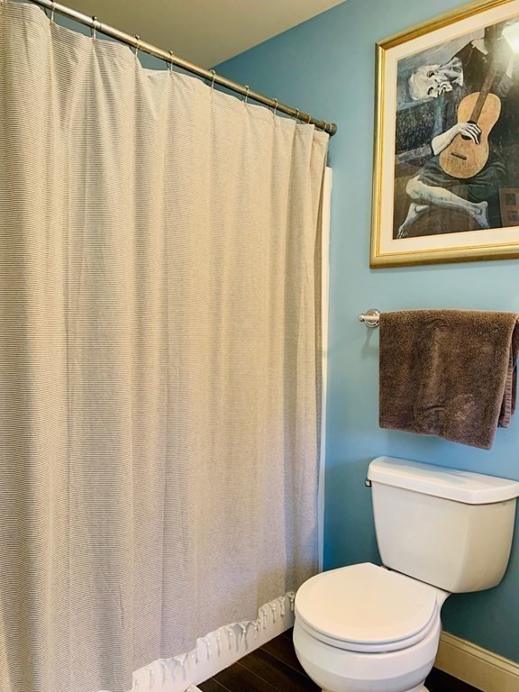 696 Florence Road Northampton, MA 01062 - Photo 20 of 35 a white toilet sitting next to a shower curtain