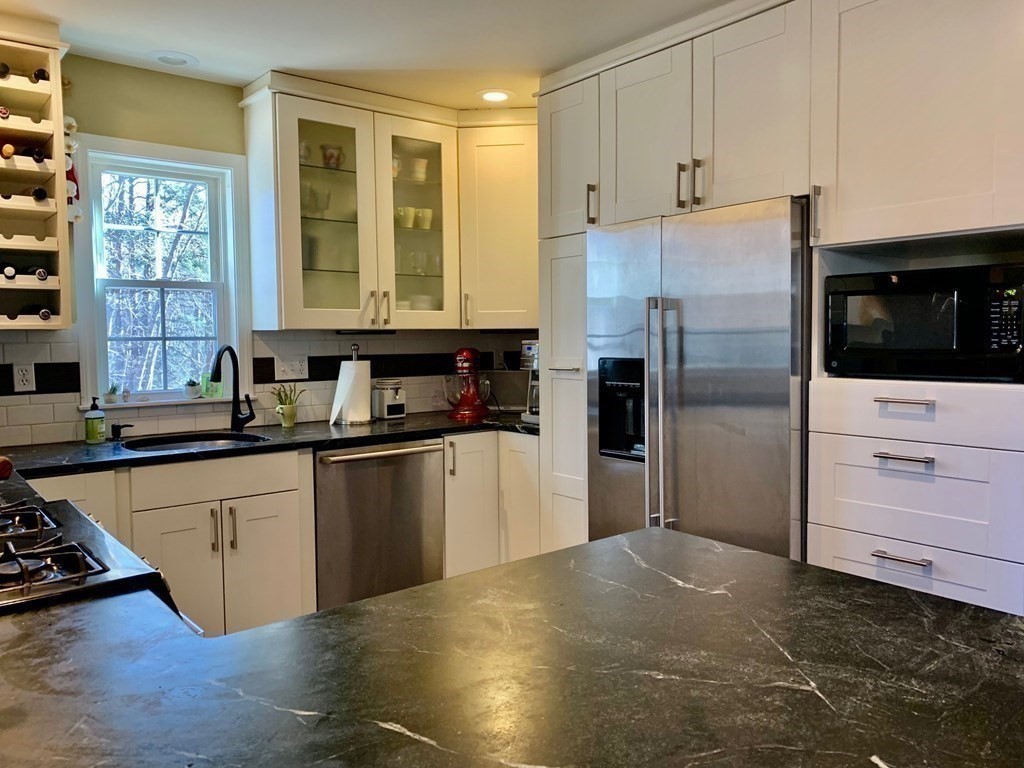 696 Florence Road Northampton, MA 01062 - Photo 10 of 35 a kitchen with granite countertop a refrigerator and a stove