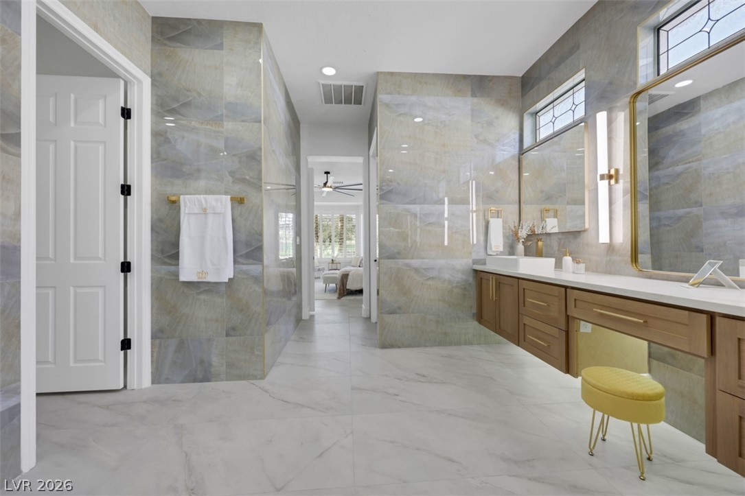 5015 Rivedro Street Las Vegas, NV 89135 - Photo 33 of 91 A spacious primary bathroom boasts a dual vanity, sleek flooring, and ample lighting.