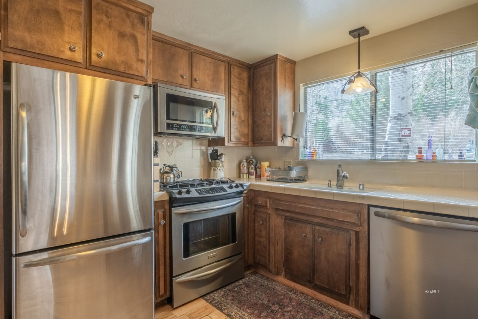 234 Brook Lane Bishop, CA 93514 - Photo 16 of 33 a kitchen with stainless steel appliances granite countertop a refrigerator a sink a stove and white cabinets with wooden floor