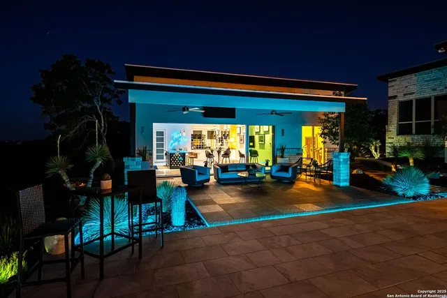 a view of a patio with table and chairs potted plants and floor to ceiling window