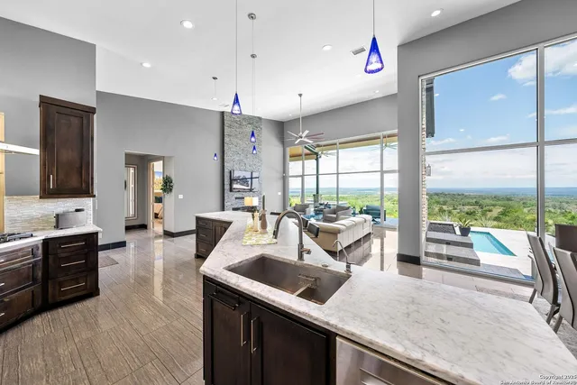 a kitchen with counter top space a sink and living room view