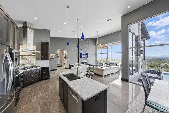 a large kitchen with kitchen island a large counter top space a sink stainless steel appliances and cabinets