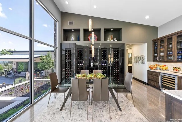 a dining room with stainless steel appliances granite countertop furniture a rug kitchen view and a large window
