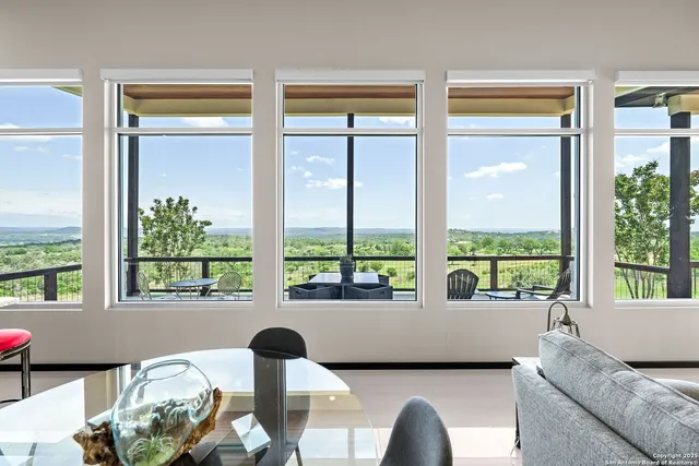 a living room with furniture and floor to ceiling windows