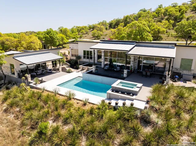 an aerial view of a house with swimming pool garden and patio