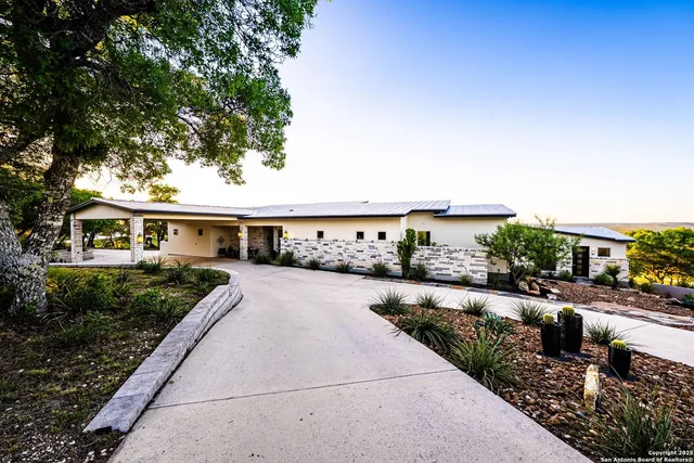 a front view of a house with a yard and potted plants