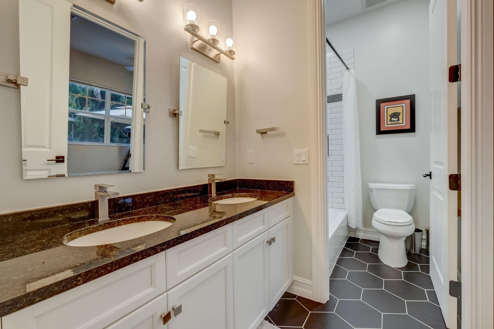 19199 Southeast Daniel Lane Jupiter, FL 33469 - Photo 25 of 49 a bathroom with a granite countertop sink a toilet and a mirror