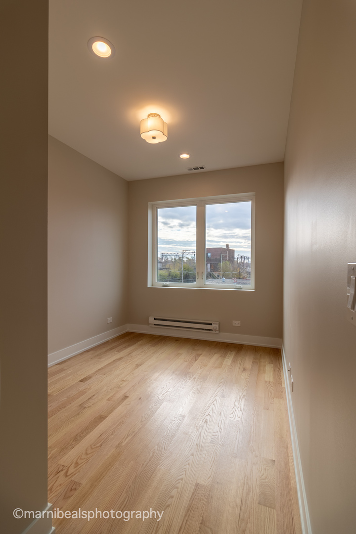 1349 East Marquette Road Chicago, IL 60637 - Photo 16 of 26 an empty room with wooden floor and windows