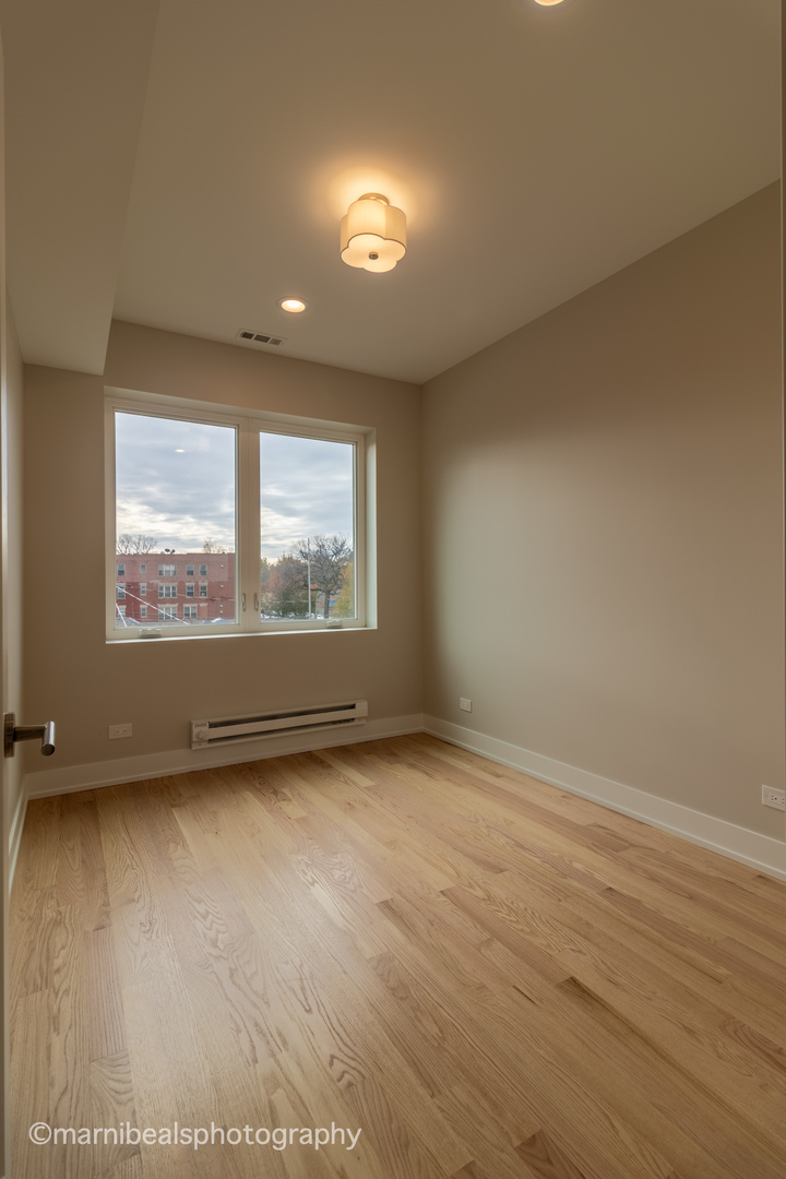 1349 East Marquette Road Chicago, IL 60637 - Photo 17 of 26 an empty room with wooden floor and windows