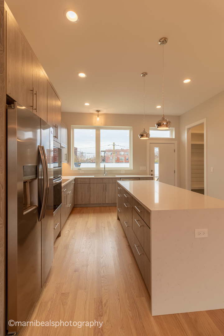 1349 East Marquette Road Chicago, IL 60637 - Photo 4 of 26 a large kitchen with stainless steel appliances kitchen island a large counter top and a refrigerator