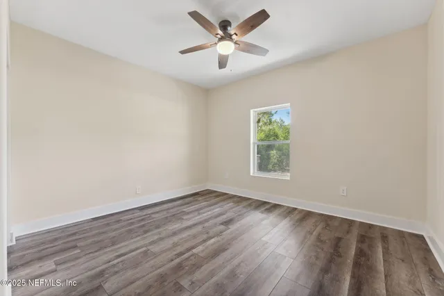 an empty room with wooden floor and window