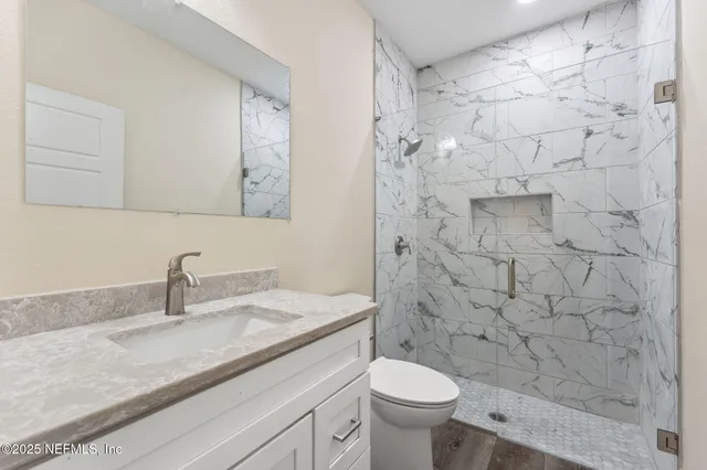 a bathroom with a sink a toilet and shower