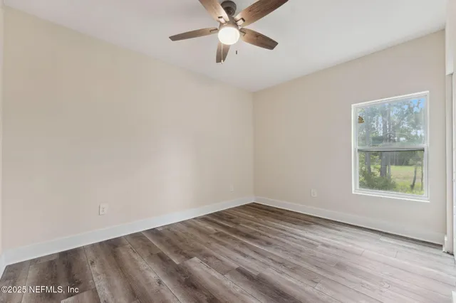 an empty room with a window and a fan