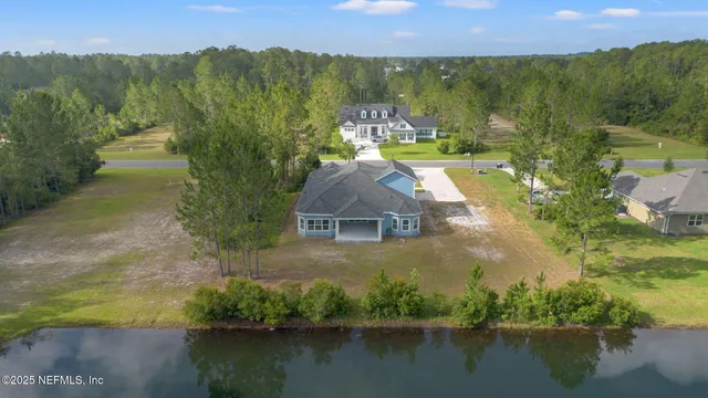 an aerial view of residential houses with outdoor space and lake view