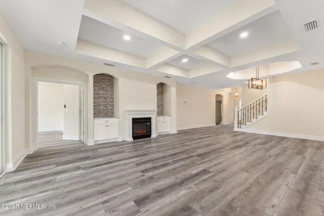 a view of empty room with wooden floor and fireplace