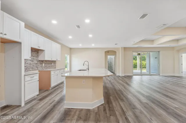 a large kitchen with a lot of cabinets and wooden floor