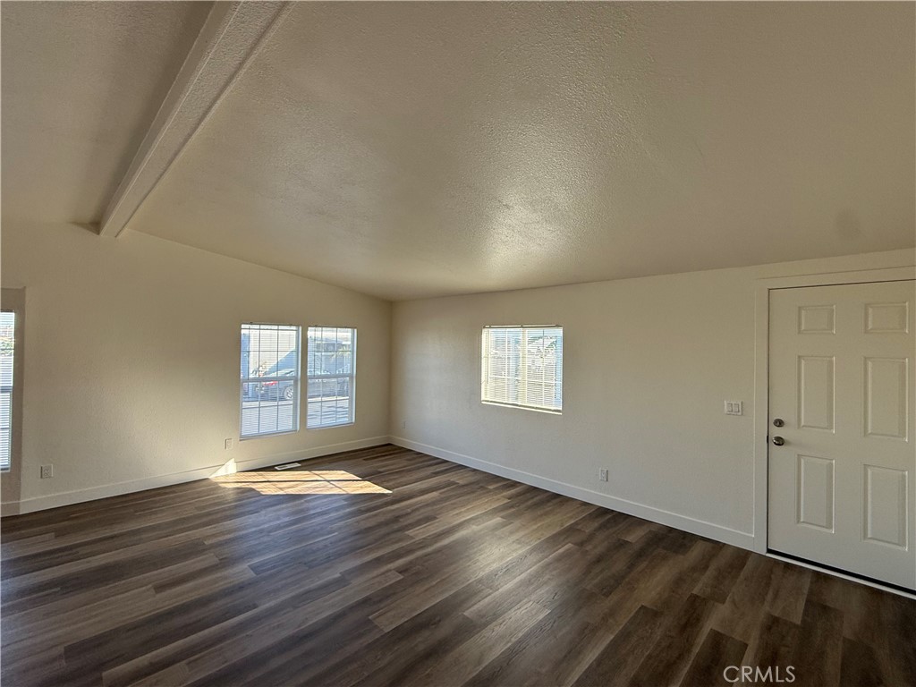 7850 Slater Avenue, Unit 99 Huntington Beach, CA 92647 - Photo 3 of 16 an empty room with wooden floor and windows