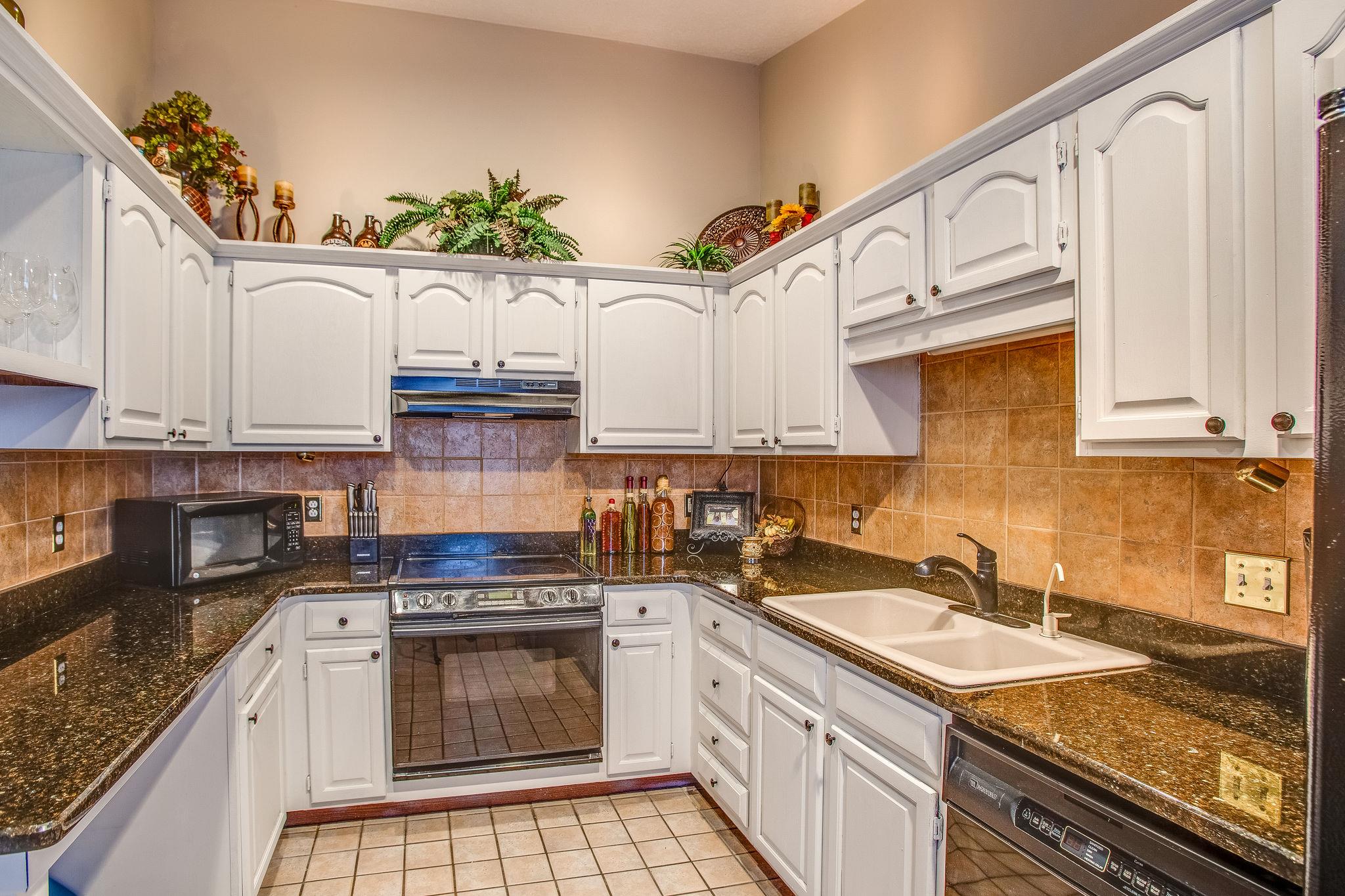 2133 Lee Road Spring Hill, TN 37174 - Photo 8 of 30 a kitchen with granite countertop a sink a stove and cabinets