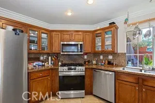 a kitchen with stainless steel appliances granite countertop a stove a sink and a microwave