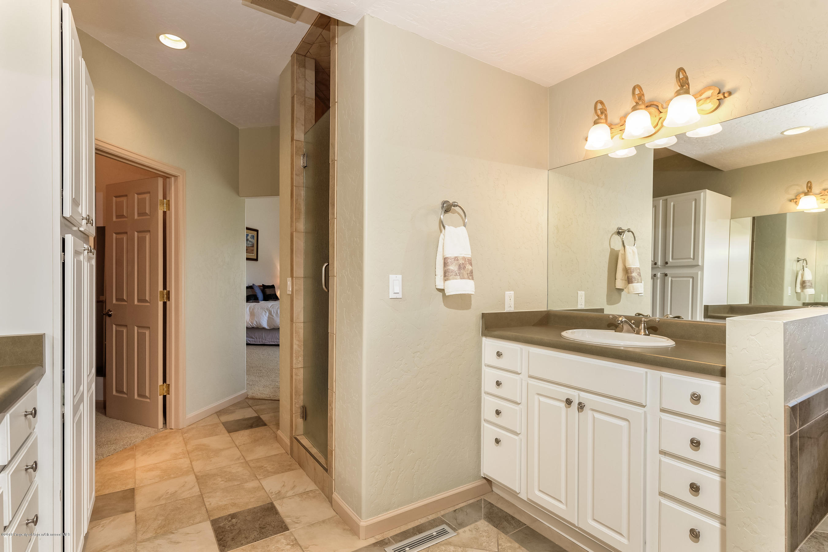 1359 County Road 294 Rifle, CO 81650 - Photo 17 of 31 a bathroom with a granite countertop sink a mirror and a shower