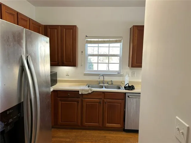 a kitchen with stainless steel appliances granite countertop a sink a refrigerator and a stove