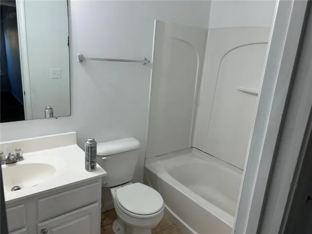 a white toilet sitting next to a bath tub