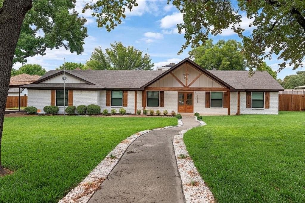 3509 West Sublett Road Arlington, TX 76017 - Photo 1 of 39 White brick exterior with natural wood shutters, a dark shingle roof, and a wood-finish front door