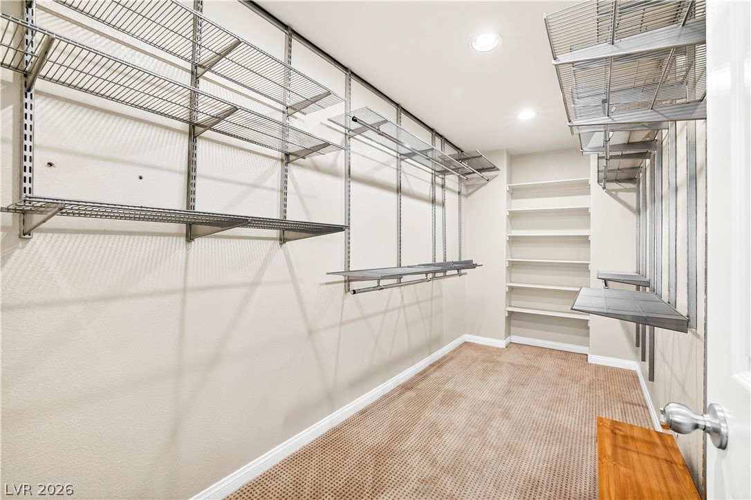 1135 Calico Ridge Drive Henderson, NV 89011 - Photo 36 of 86 Ample storage solutions abound in this meticulously organized walk-in closet, maximizing utility with integrated shelving.