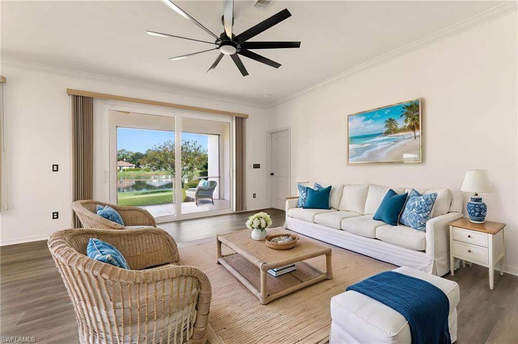 223 Stanhope Circle Naples, FL 34104 - Photo 5 of 41 Spacious living area featuring wood-finish flooring, a contemporary ceiling fan, and crown molding