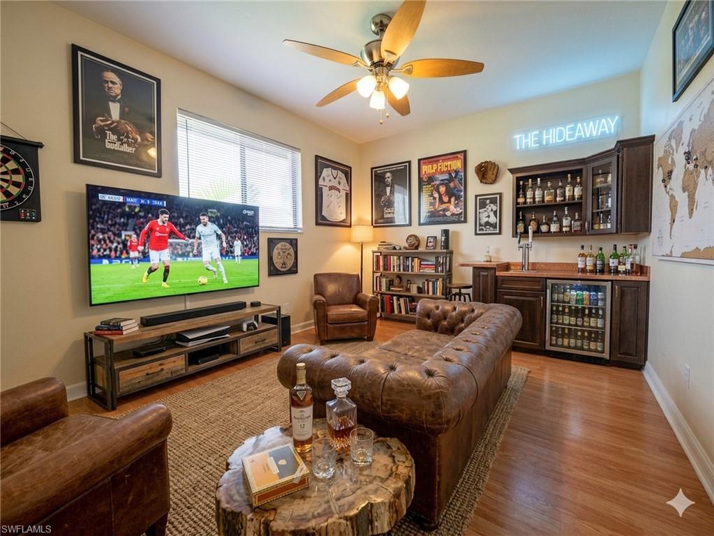 18414 Tulip Road Fort Myers, FL 33967 - Photo 28 of 37 Spacious entertainment area featuring wood-finish flooring, a built-in wet bar with cabinetry and beverage refrigerator, and a ceiling fan