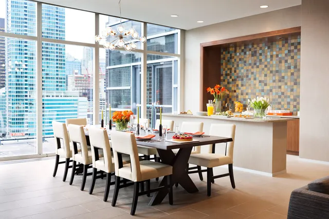 a dining room with furniture large windows and a chandelier