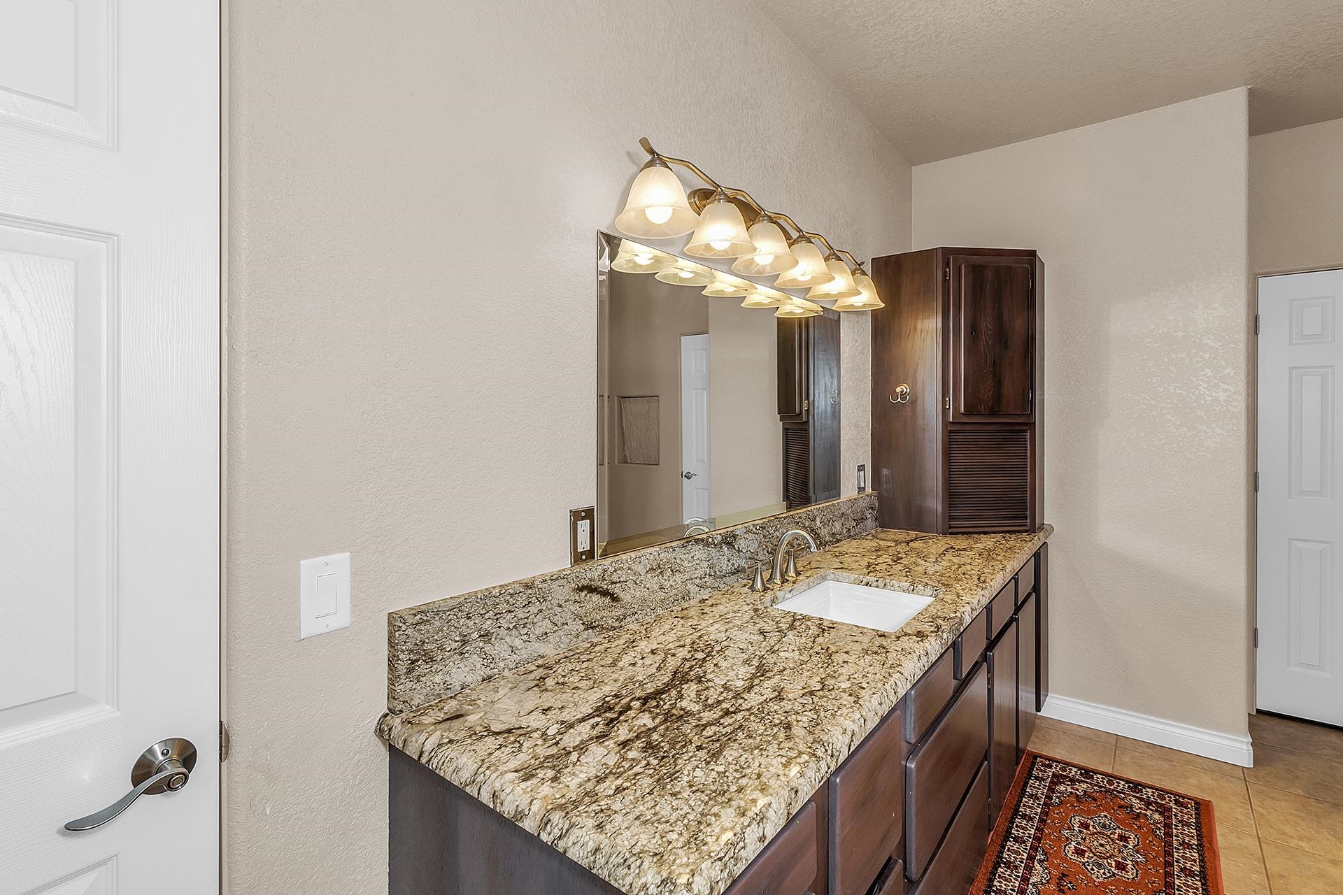 894 25 Road Grand Junction, CO 81505 - Photo 17 of 42 a bathroom with a granite countertop sink and a mirror