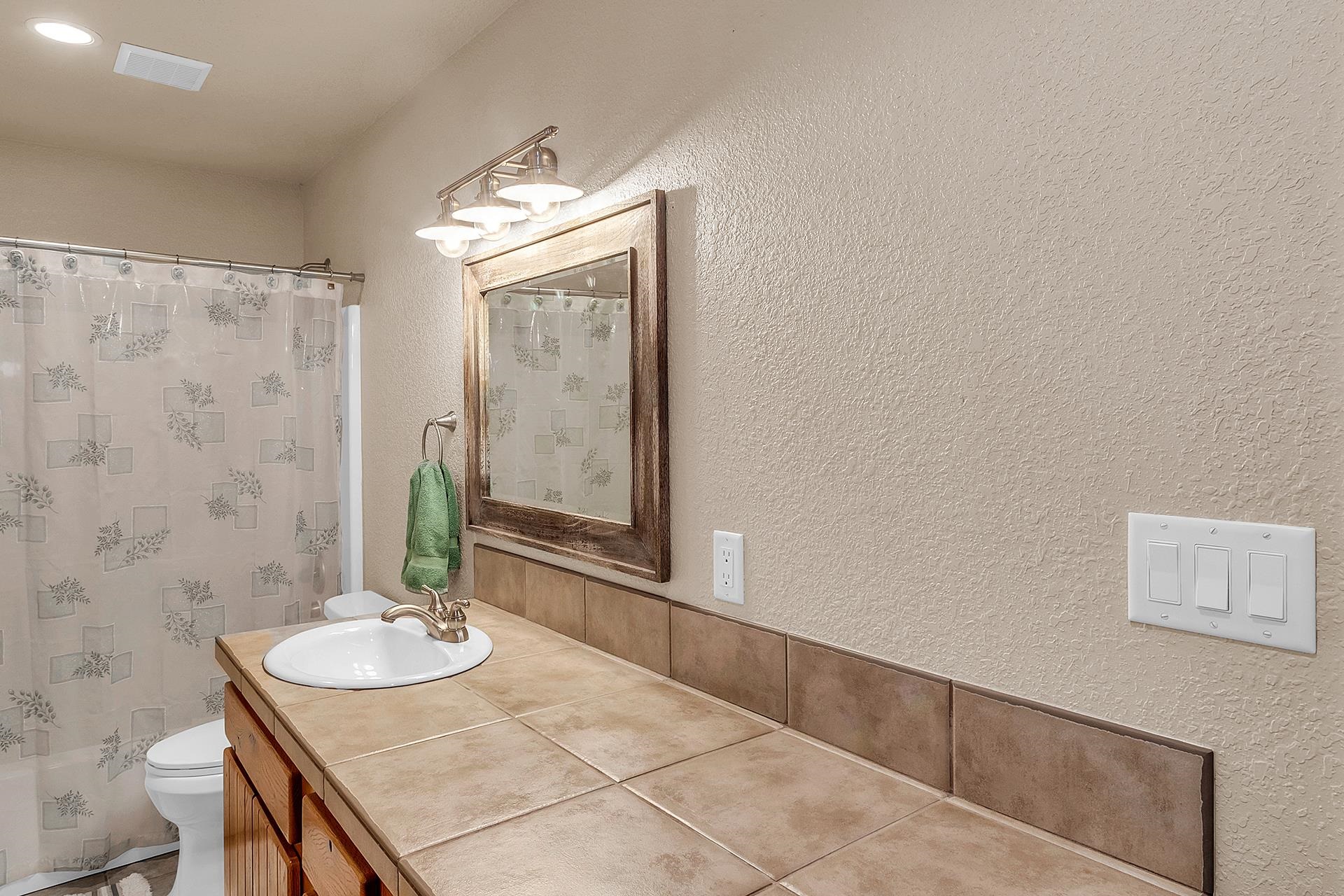 894 25 Road Grand Junction, CO 81505 - Photo 30 of 42 a bathroom with a granite countertop sink a mirror and a shower