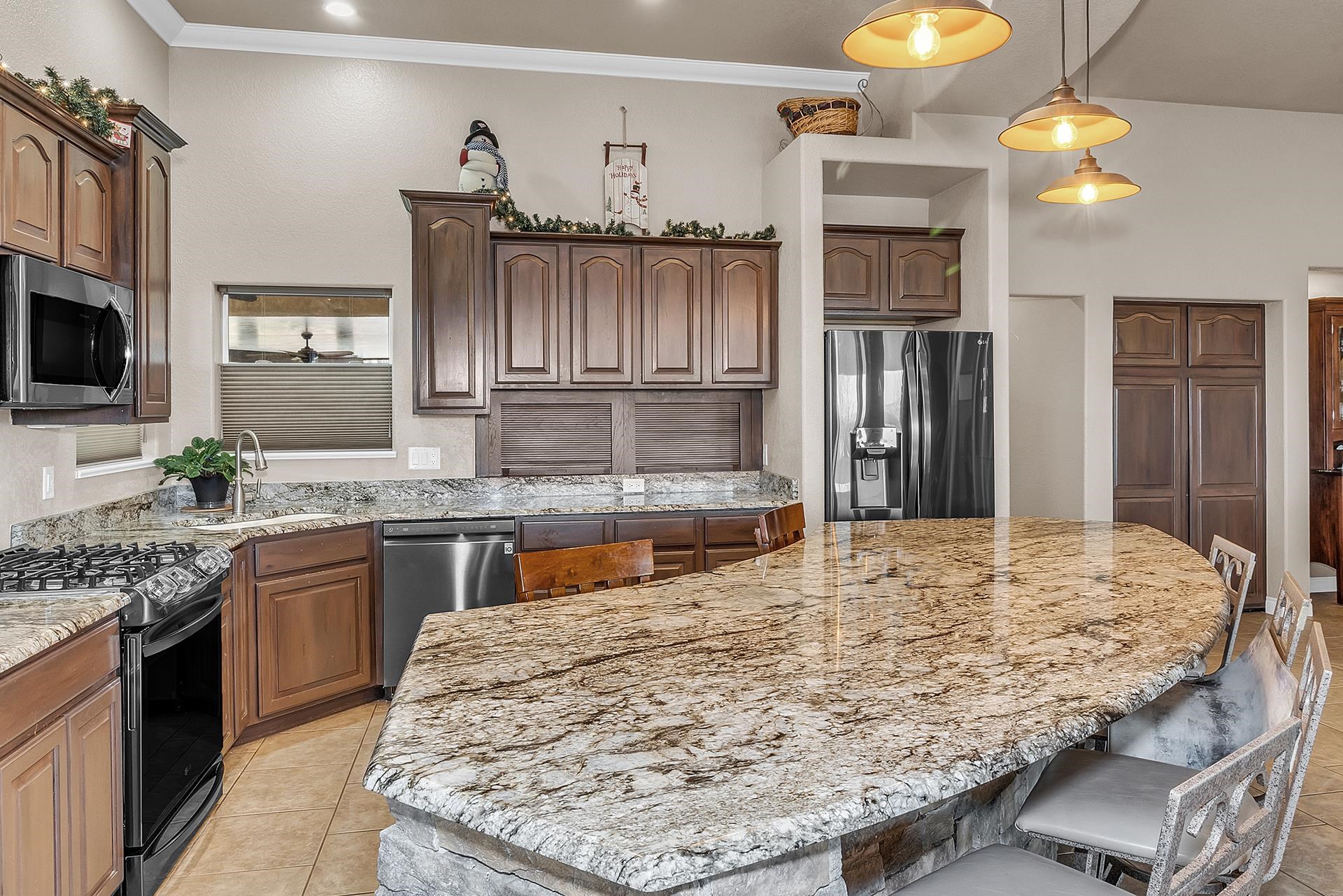 894 25 Road Grand Junction, CO 81505 - Photo 10 of 42 a kitchen with kitchen island granite countertop a stove and cabinets