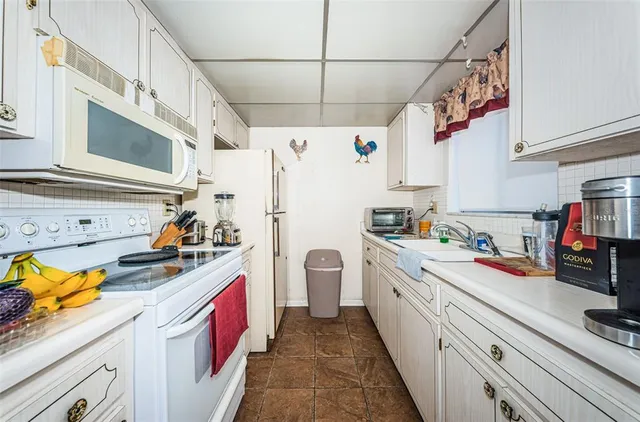 a kitchen with a white stove top oven and refrigerator